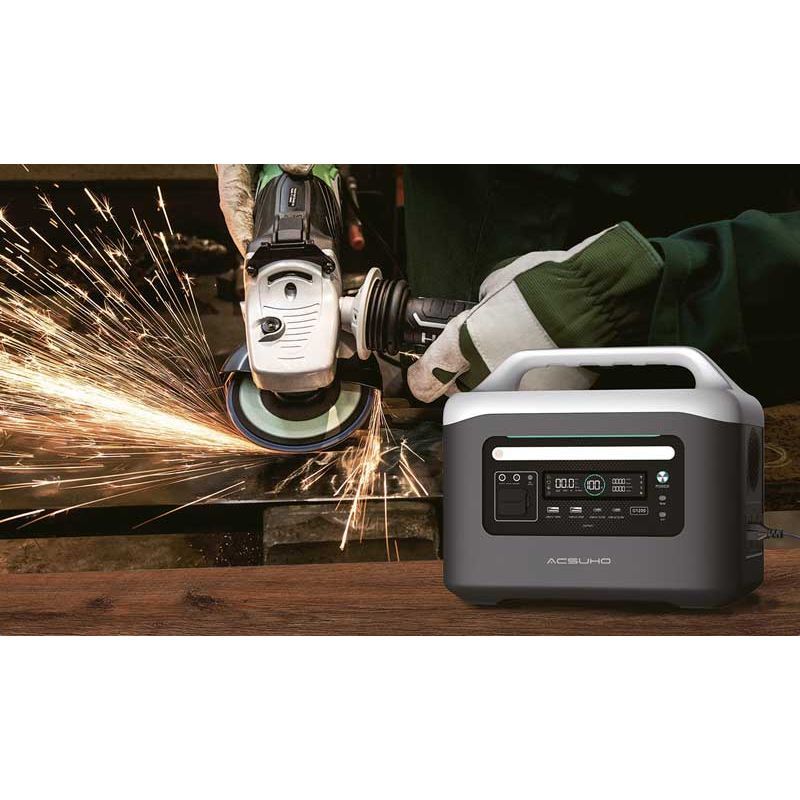 Person using an angle grinder with sparks, next to an Aeon Guardians G1200 power station on a wooden surface.