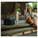 Two people sitting on a wooden deck with outdoor heaters and a EcoFlow DELTA 2 Max Portable Power Station