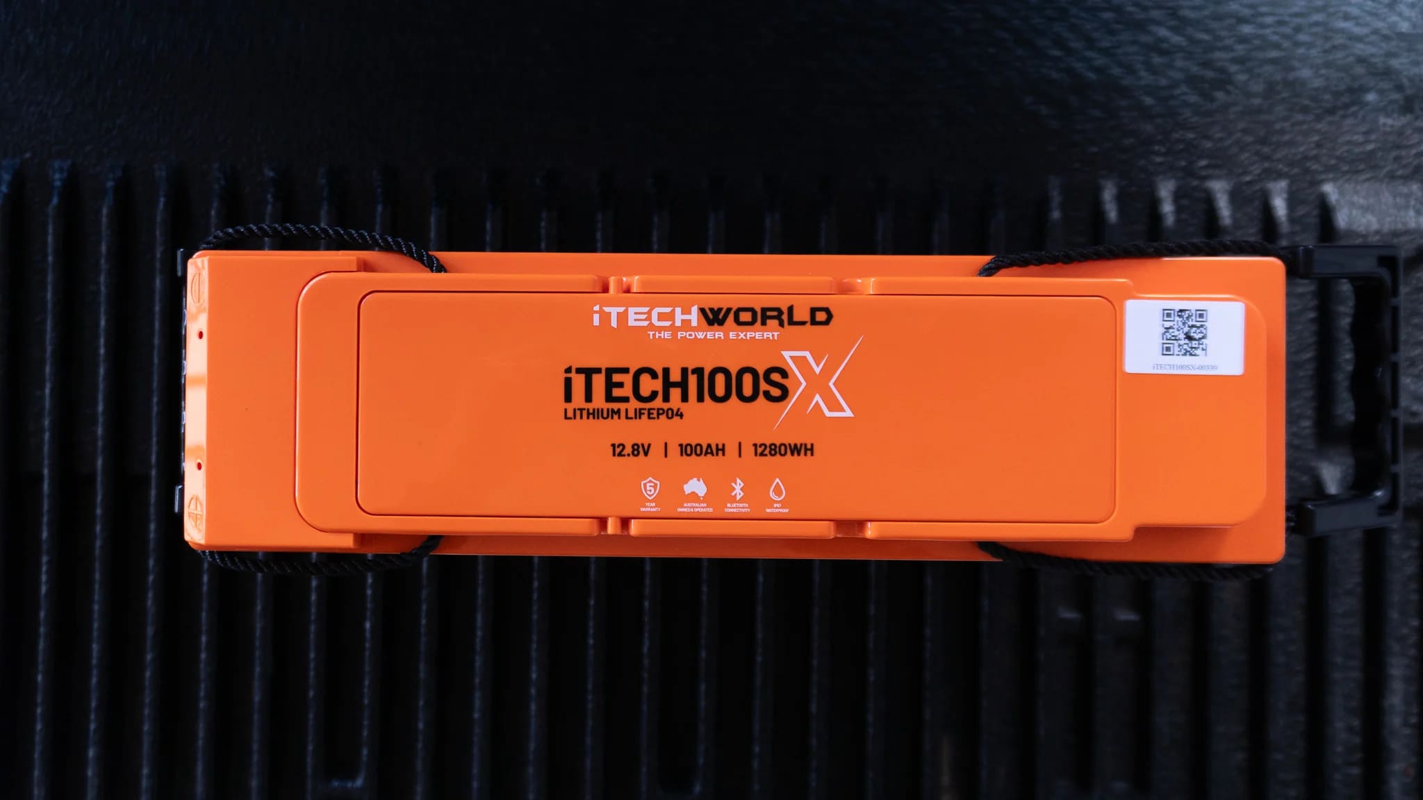 iTechworld iTECH100SX Slim Deep Cycle Lithium Battery with Bluetooth LiFePO4 100Ah - Top view of battery on a plastic base.